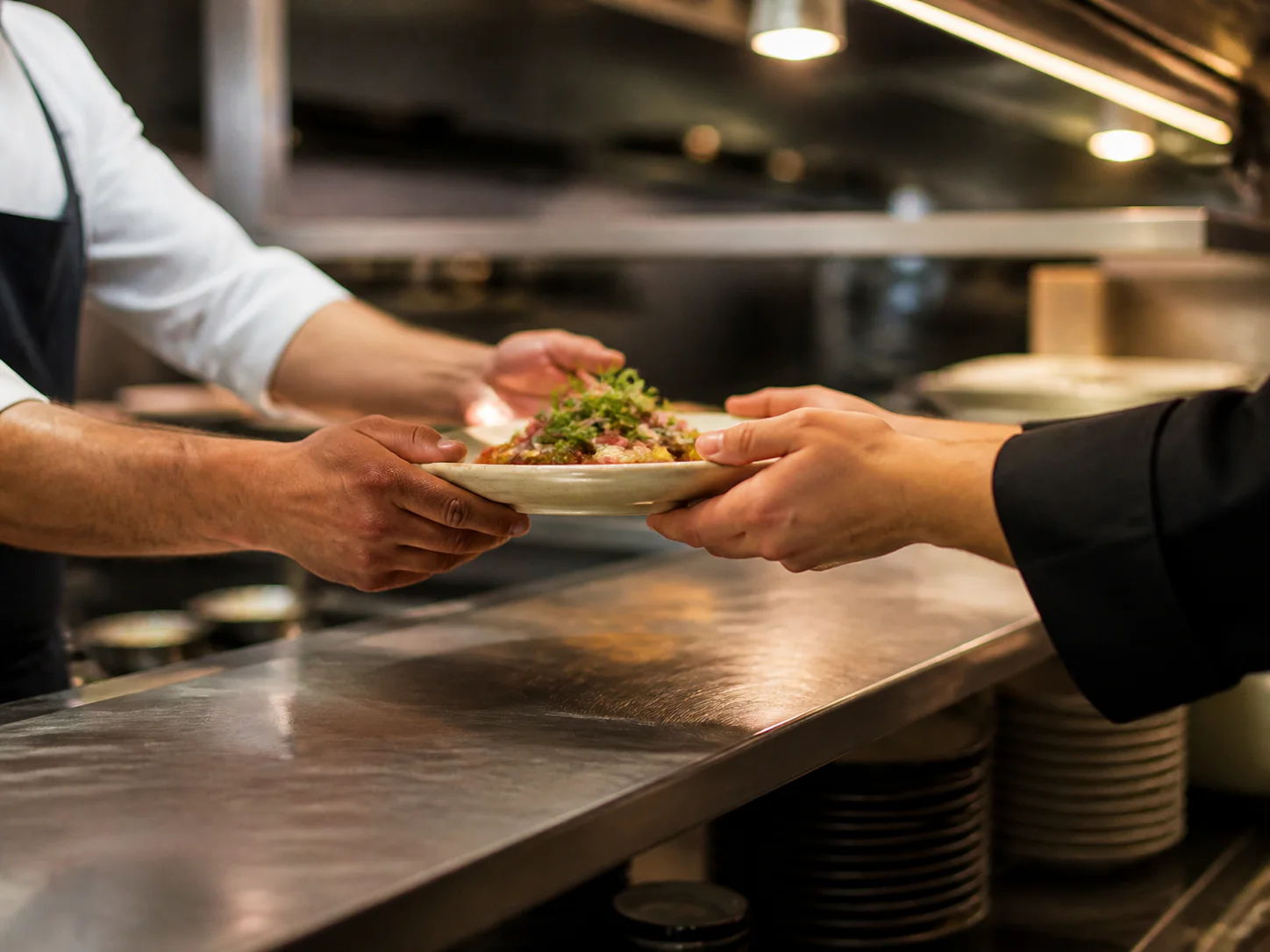 Une assiette passe d'un membre de l'équipe à un autre pendant le service